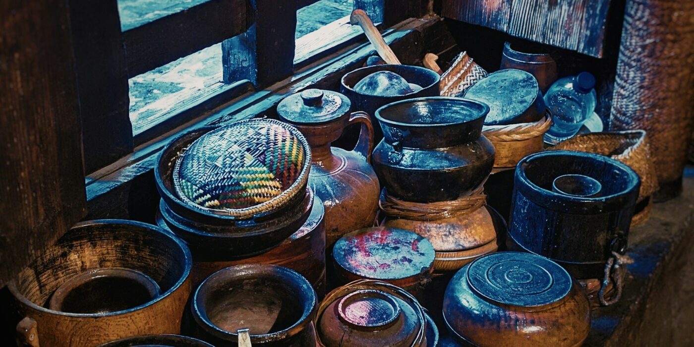 Assortment of kitchen gadgets and cookware including cast iron skillet and stainless steel pots on a home kitchen counter