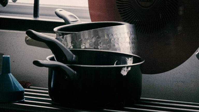 Three types of cookware on a kitchen counter showing ceramic vs stainless steel vs non-stick options