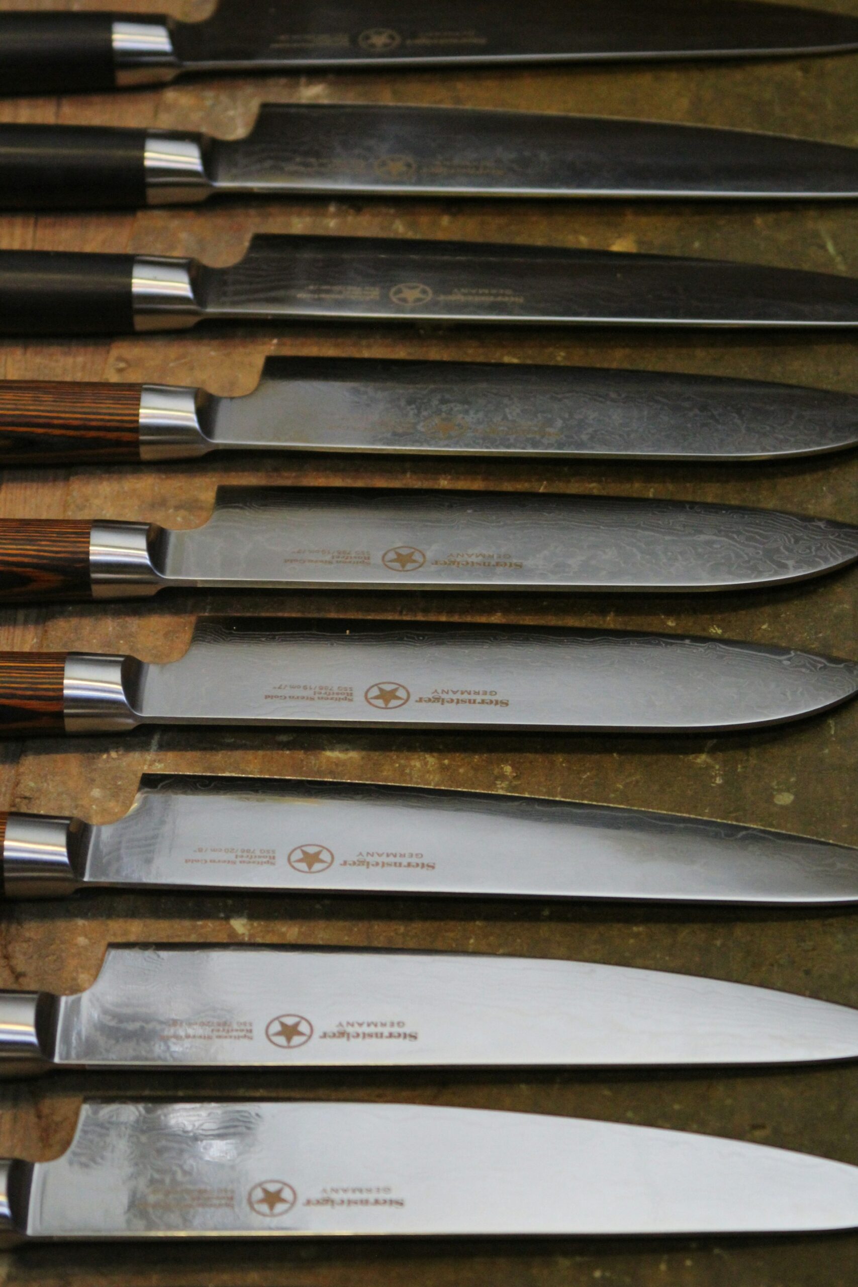  Multiple kitchen knife handles showing the difference between wood grain and synthetic materials for grip and durability