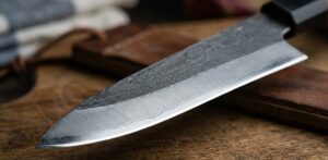 Close-up of a kitchen knife blade edge showing the steel bevel, illustrating the difference between hard and soft knife steel